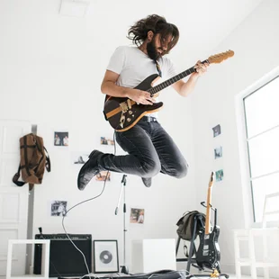Akustiktapete - Ein Mann spielt E-Gitarre in einem Raum der mit Schallschluckender Akkustik Tapete tapeziert ist.